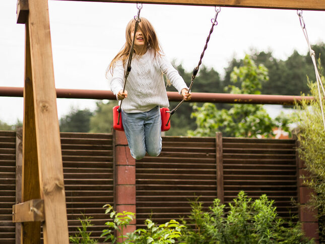 kinderen-op-de-schommel-meisje-swingende-op-een-schommel-de-tuin-zomerplezier